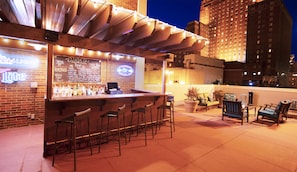 An outdoor bar area with a chalkboard menu, bar stools, and a seating area with chairs and tables. - DoubleTree by Hilton Milwaukee Downtown (Milwaukee)