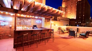An outdoor bar area with a neon sign, a chalkboard menu, and a seating arrangement with chairs and tables. - DoubleTree by Hilton Milwaukee Downtown (Milwaukee)