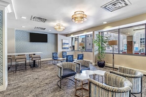 A hotel lobby with a bar, seating area, and large windows. - DoubleTree by Hilton Milwaukee Downtown (Milwaukee)