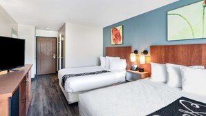 A hotel room with two beds, a TV, a desk, and artwork on the walls. - La Quinta Inn & Suites by Wyndham Helena (Helena)