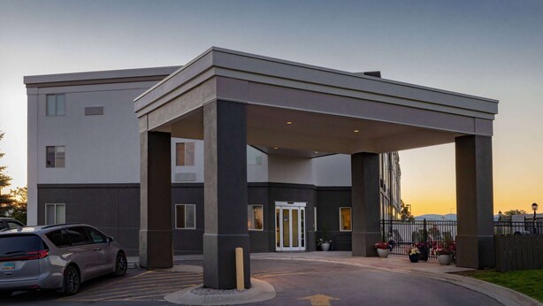 A modern building with a covered entrance, a car parked in front, and a clear sky. - La Quinta Inn & Suites by Wyndham Helena (Helena)
