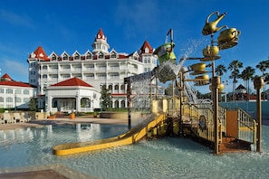 A hotel with a large pool and a water fountain.