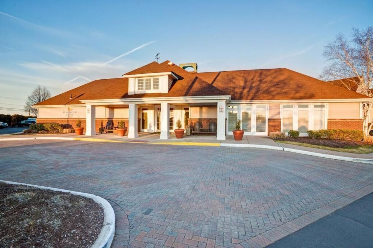 A building with a brick facade, a covered entrance area, and a paved driveway.
