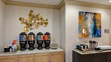A coffee station with four dispensers labeled Regular, Robust, Decaf, and Hot Water.