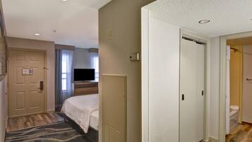 A hotel room with a bed, a television, a wardrobe, and a bathroom visible through an open door.