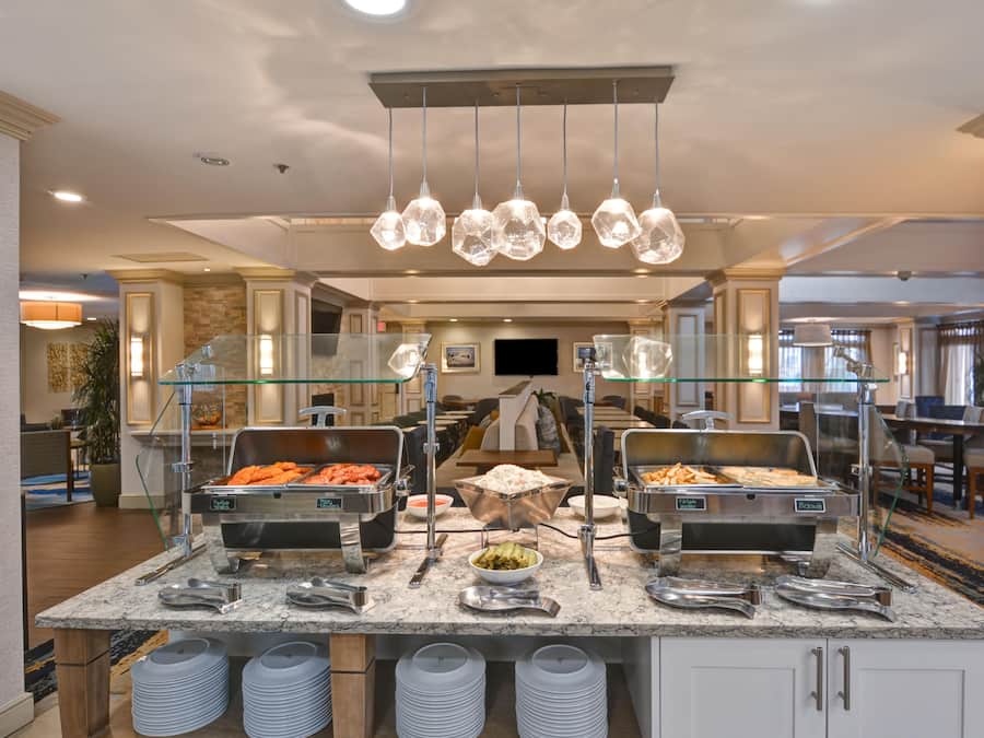 A buffet setup with various food items and serving utensils.