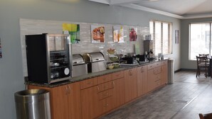 A modern kitchen with a built-in grill, a coffee station, and a breakfast bar.