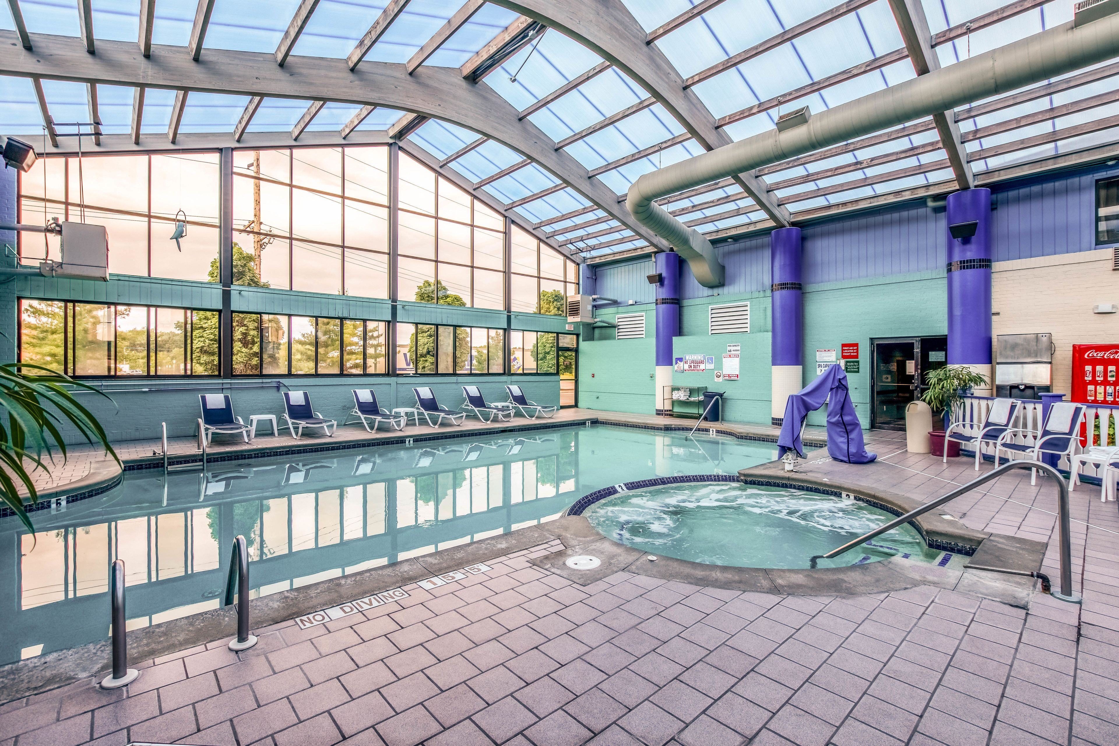 Piscina interna com espreguiçadeiras e área de hidromassagem.
