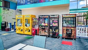 A variety of arcade games, a vending machine, and a seating area with a view of the sky. - Country Inn & Suites by Radisson, Muskegon, MI (Muskegon)