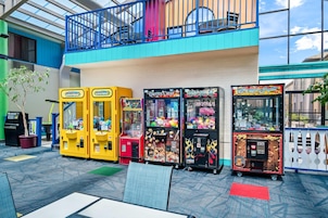 A variety of arcade games, a vending machine, and a seating area with a view of the sky.