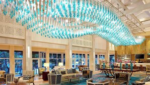 A spacious lobby with a large seating area, a bar, and a view of a tropical landscape through the windows. - Sheraton Bandung Hotel & Towers (Bandung)