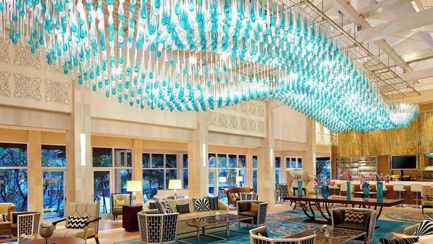 A spacious lobby with a large seating area, a bar, and a view of a tropical landscape through the windows. - Sheraton Bandung Hotel & Towers (Bandung)