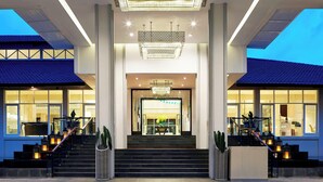 A hotel entrance with a grand staircase, a chandelier, and a large glass door. - Sheraton Bandung Hotel & Towers (Bandung)