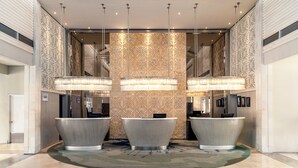 A lobby with three large, modern sinks, a patterned wall, and a chandelier. - Sheraton Bandung Hotel & Towers (Bandung)