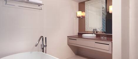 A modern bathroom with a freestanding bathtub, a vanity with a mirror, and a towel rack.