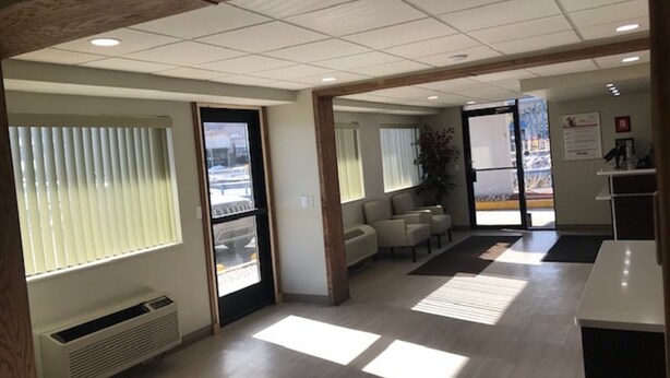A spacious office with a reception area, seating, and large windows. - Red Roof Inn Somerset, PA (Somerset)