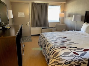 A hotel room with a bed, a desk, a chair, a TV, and a window with curtains. - Red Roof Inn Somerset, PA (Somerset)