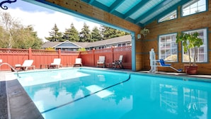 A swimming pool with lounge chairs and a wooden deck.