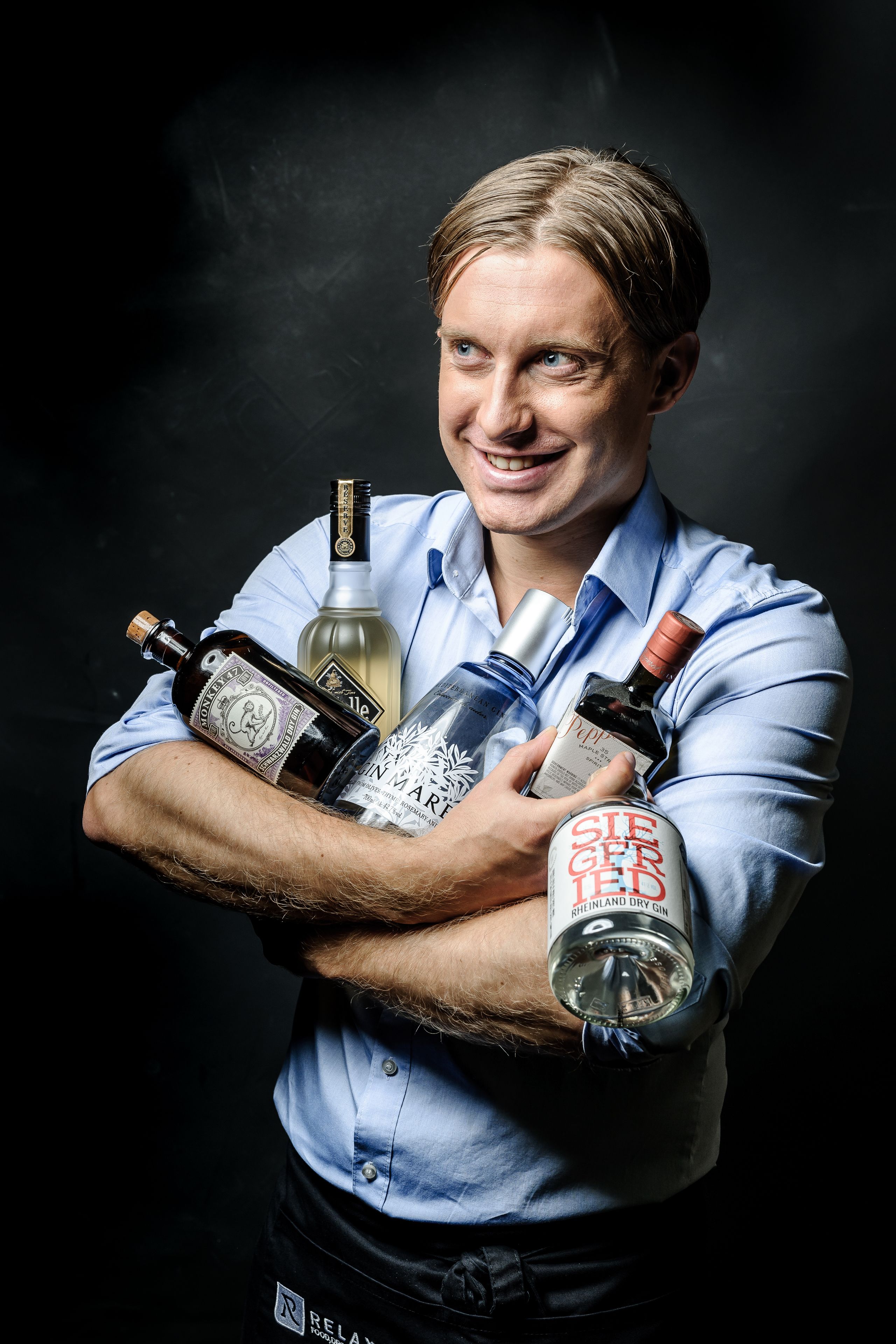 A person holding several bottles of alcohol.