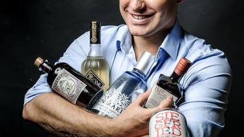 A person holding several bottles of alcohol.