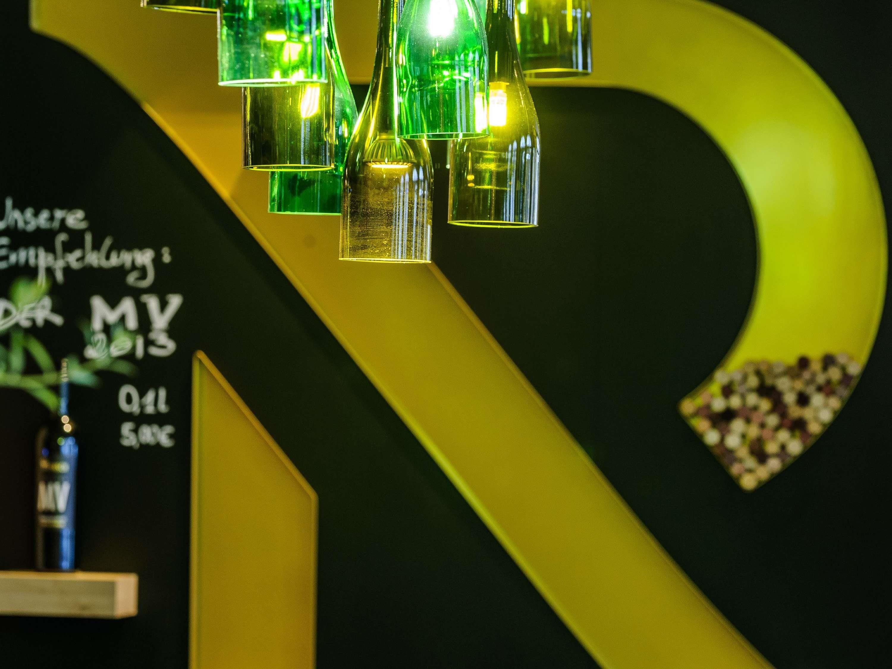A modern interior with a green and yellow color scheme, featuring a unique light fixture and a wall with text.