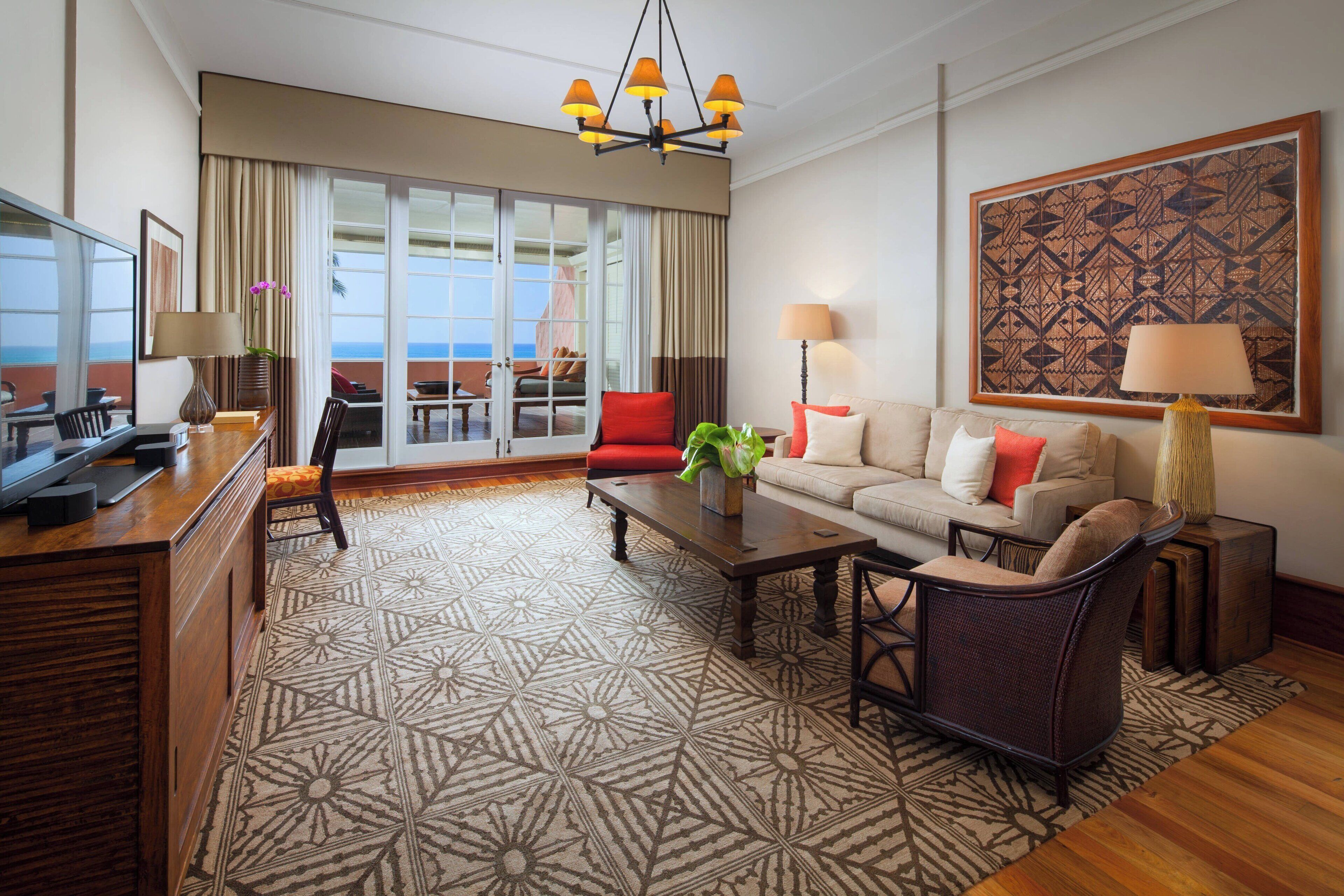 A spacious living room with a large window, a sofa, a coffee table, and a TV.