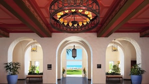 A hotel lobby with a view of the beach, arched ceilings, and large potted plants. - The Royal Hawaiian, a Luxury Collection Resort, Waikiki (Honolulu)