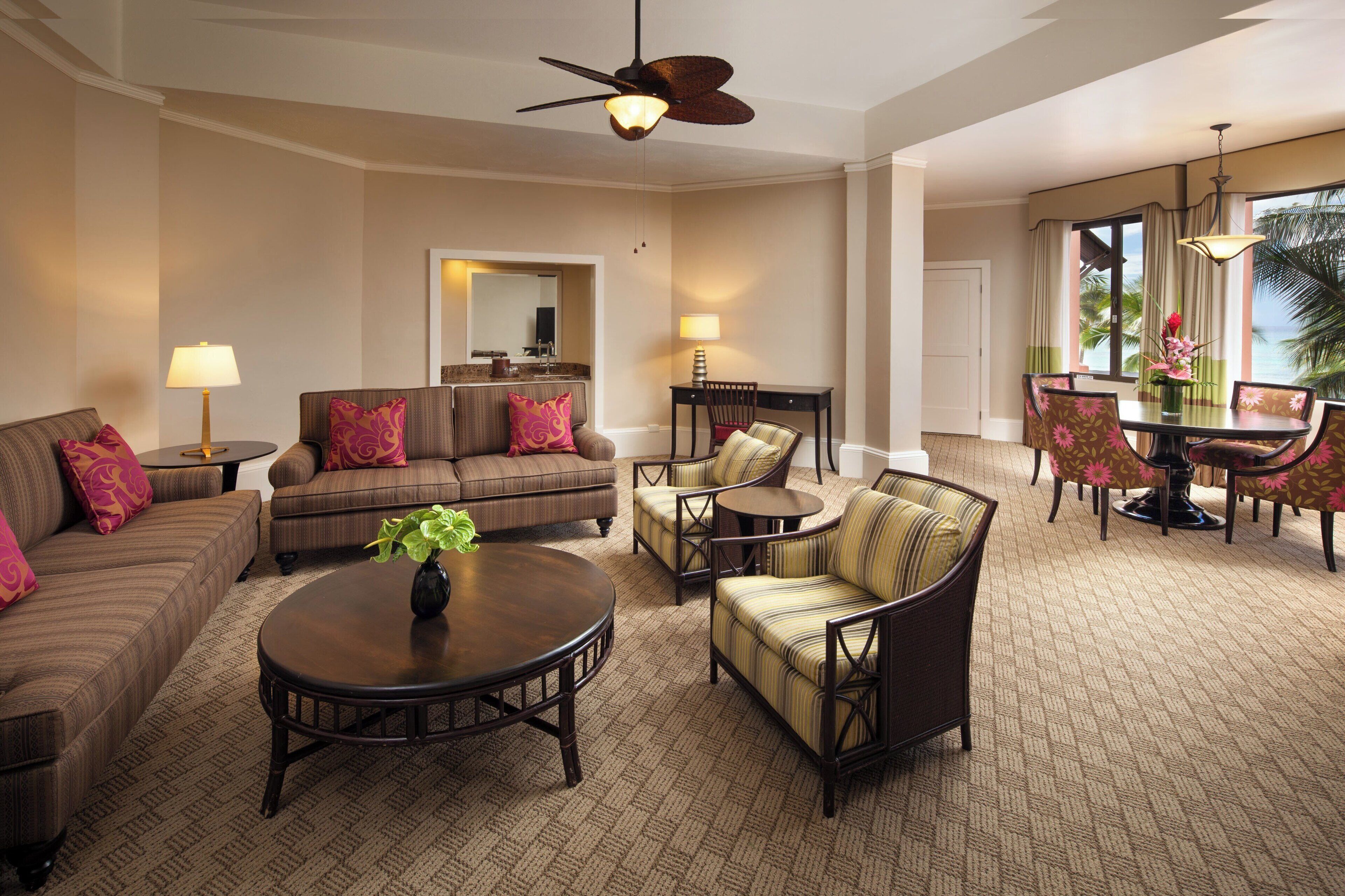 A spacious living area with a sofa, armchairs, a coffee table, and a dining table with chairs.