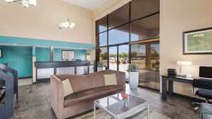 A modern lobby with a sofa, coffee table, and a reception desk. - Best Western Conway (Conway)