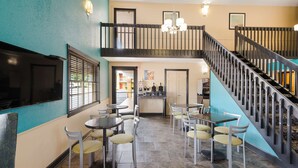 A restaurant with a staircase, multiple tables, and chairs. - Best Western Conway (Conway)
