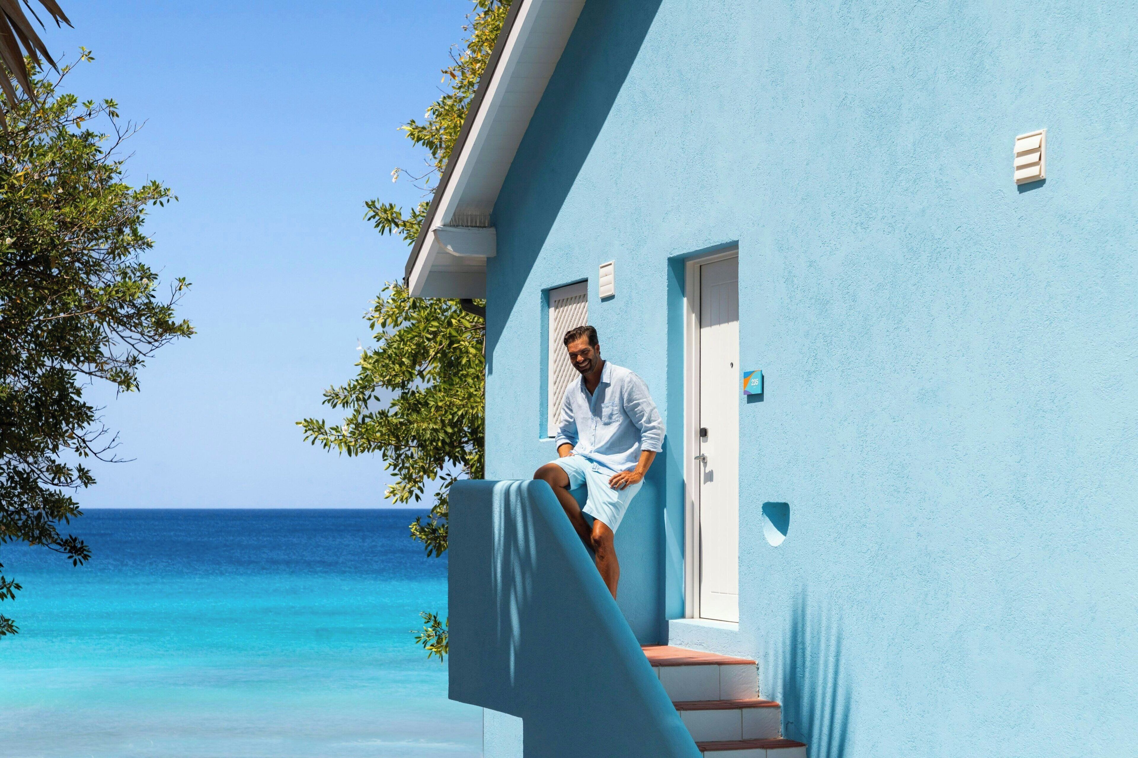 A person sitting on a balcony with a view of the ocean.