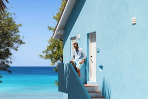 A person sitting on a balcony with a view of the ocean. - Crystal Cove, A Tribute Portfolio All-Inclusive Resort (Derricks)