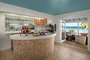 A kitchen with a curved island, a glass display case, and a coffee machine.