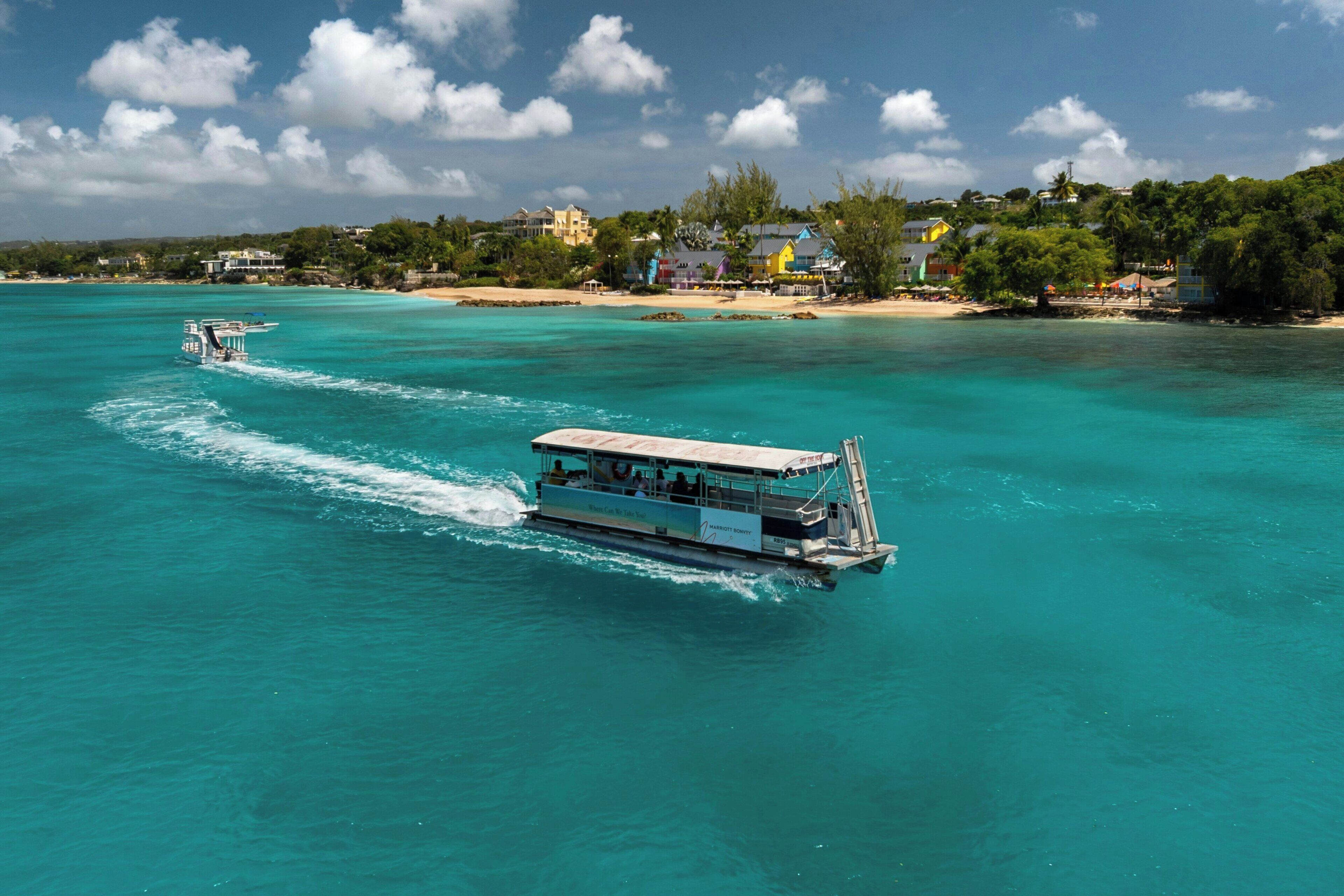 Un bateau doté d’un pont supérieur couvert et d’un pont inférieur ouvert, naviguant sur des eaux turquoise et limpides.