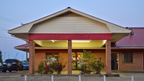 Un bâtiment à la façade rouge et beige, doté d’un porche et d’une fondation en briques.