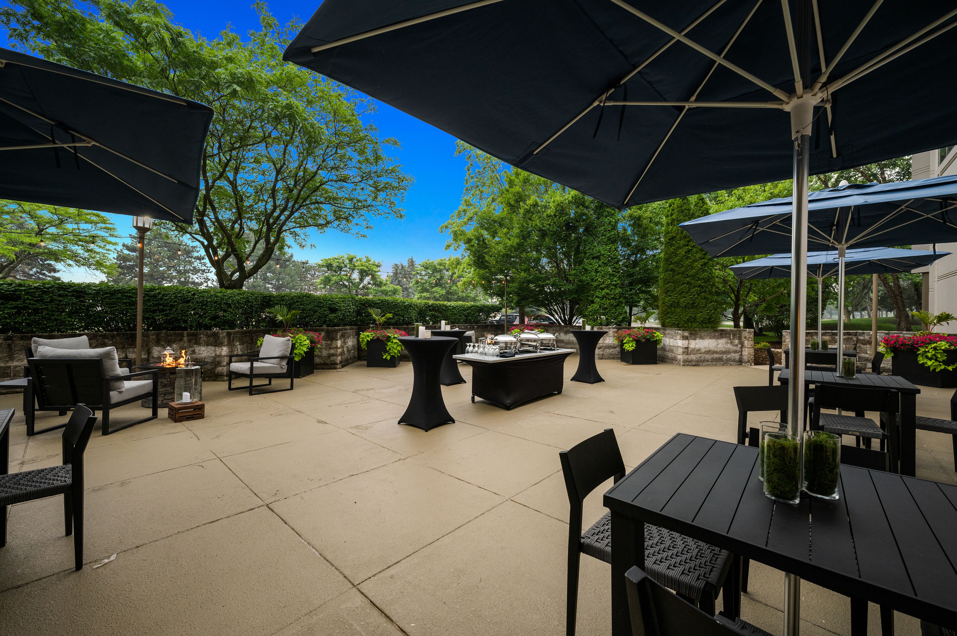 An outdoor patio area with tables, chairs, and umbrellas.