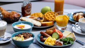 A breakfast table with various foods, drinks, and a bottle. - Novotel Nice Centre Vieux Nice (Nice)