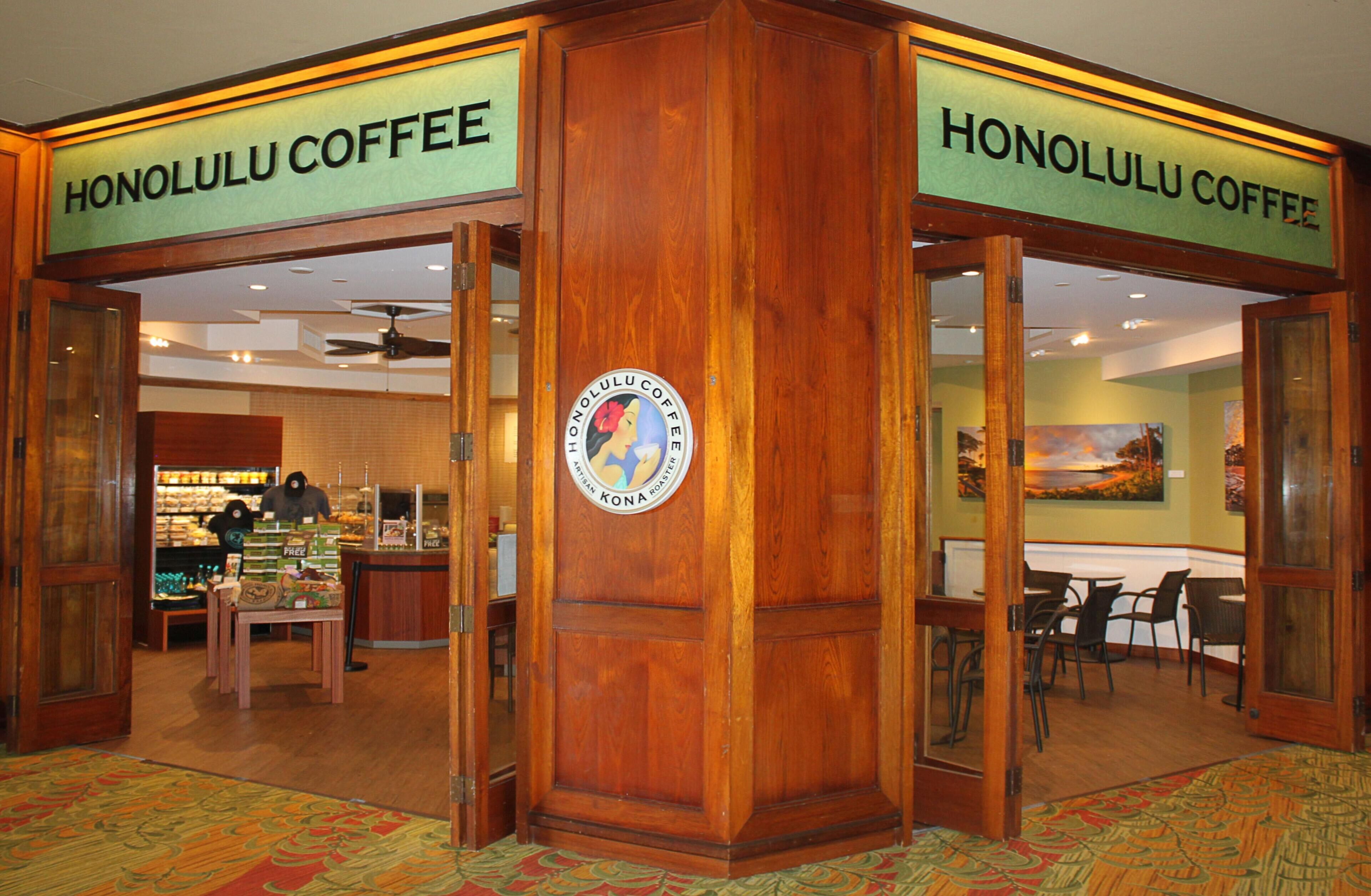 A coffee shop interior with wooden decor and a central logo.