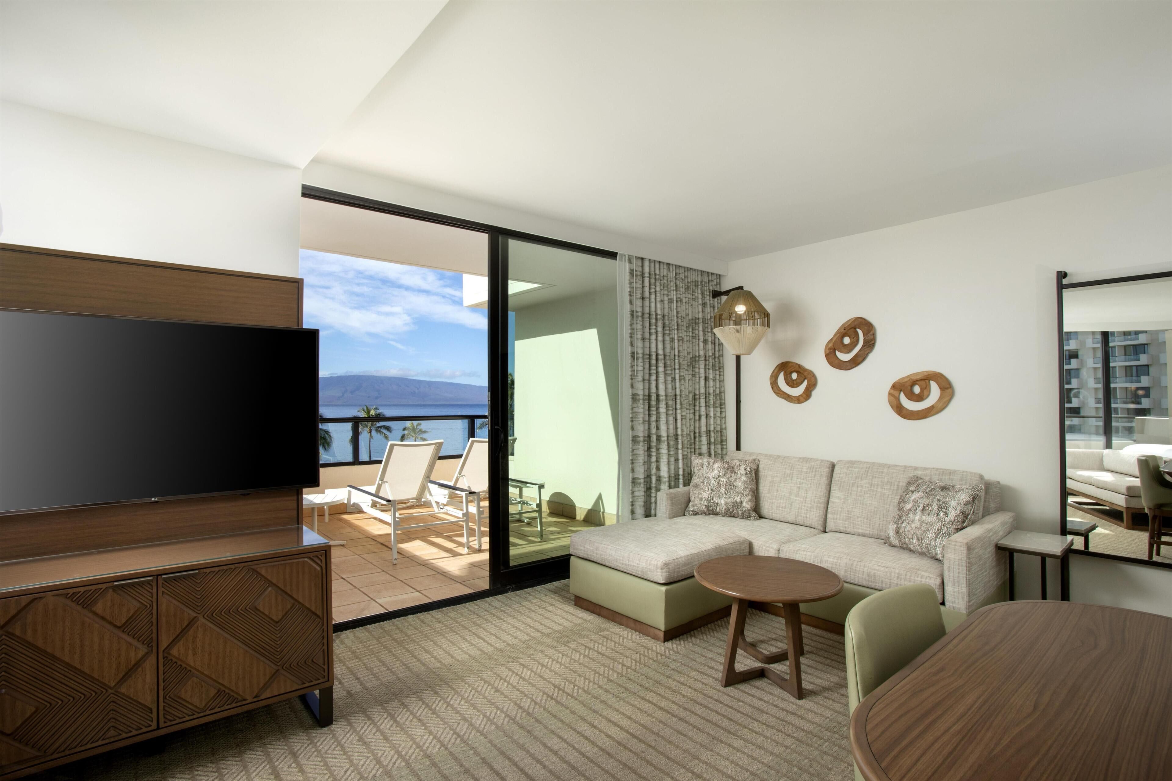 A modern living room with a television, sofa, and a dining area.