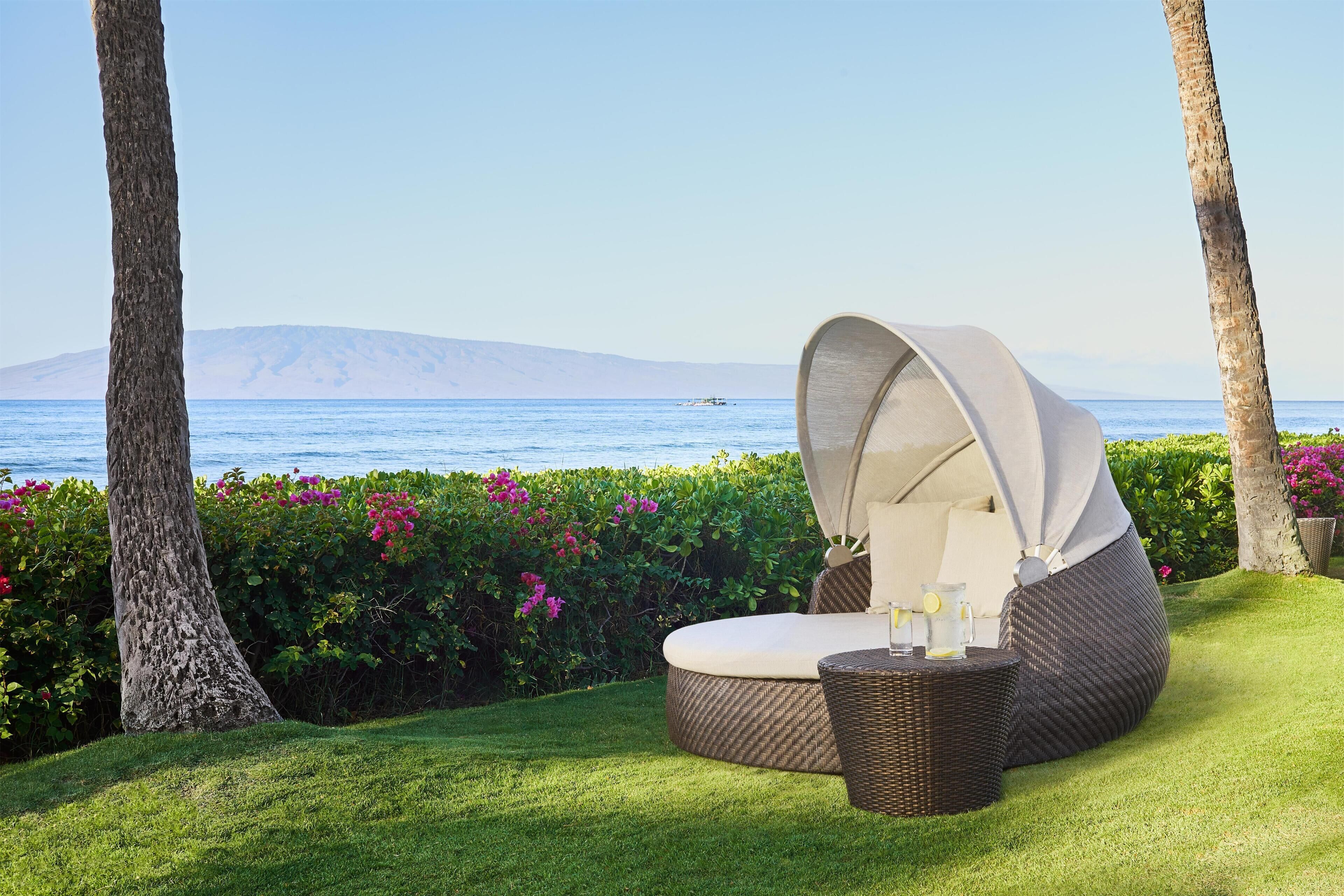 A sun lounger with a view of the sea and mountains.