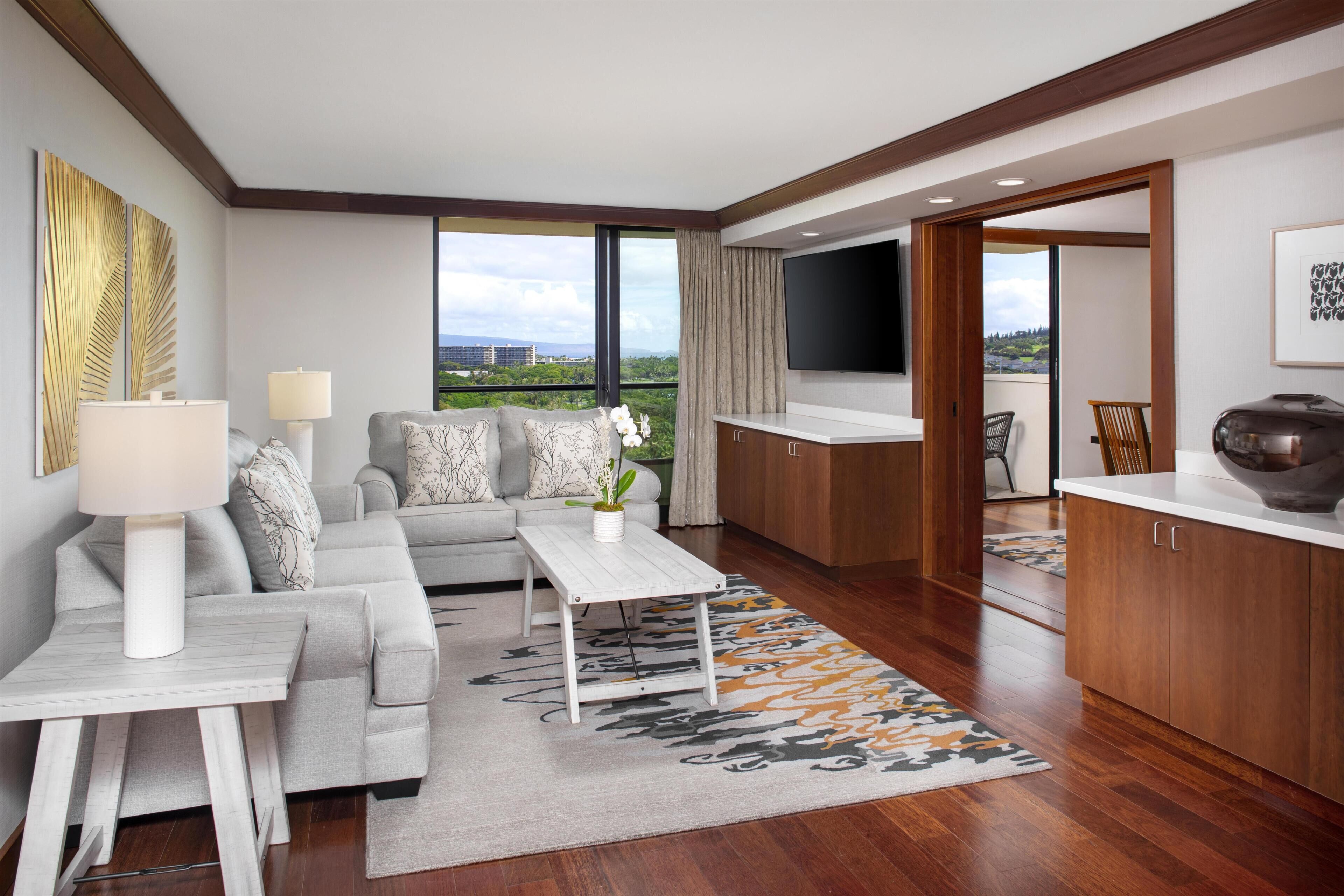 A modern living room with a sofa, coffee table, and a view of the city.
