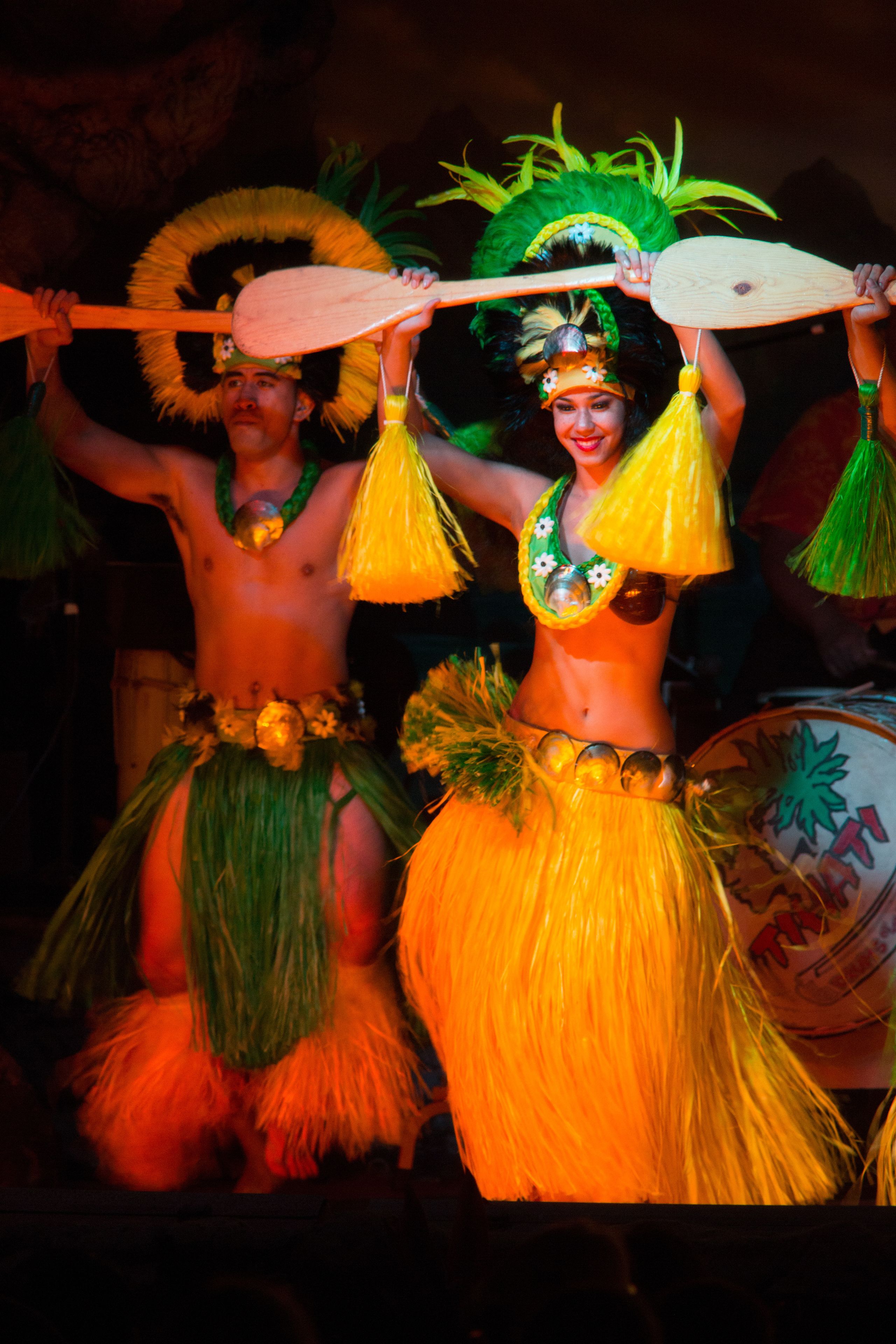 A performer in a traditional costume with a headdress and a drum.