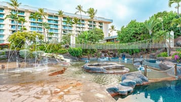 Un resort con piscina, un puente y un edificio de varios pisos.
