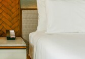 A hotel room with a bed, a nightstand, and a telephone.