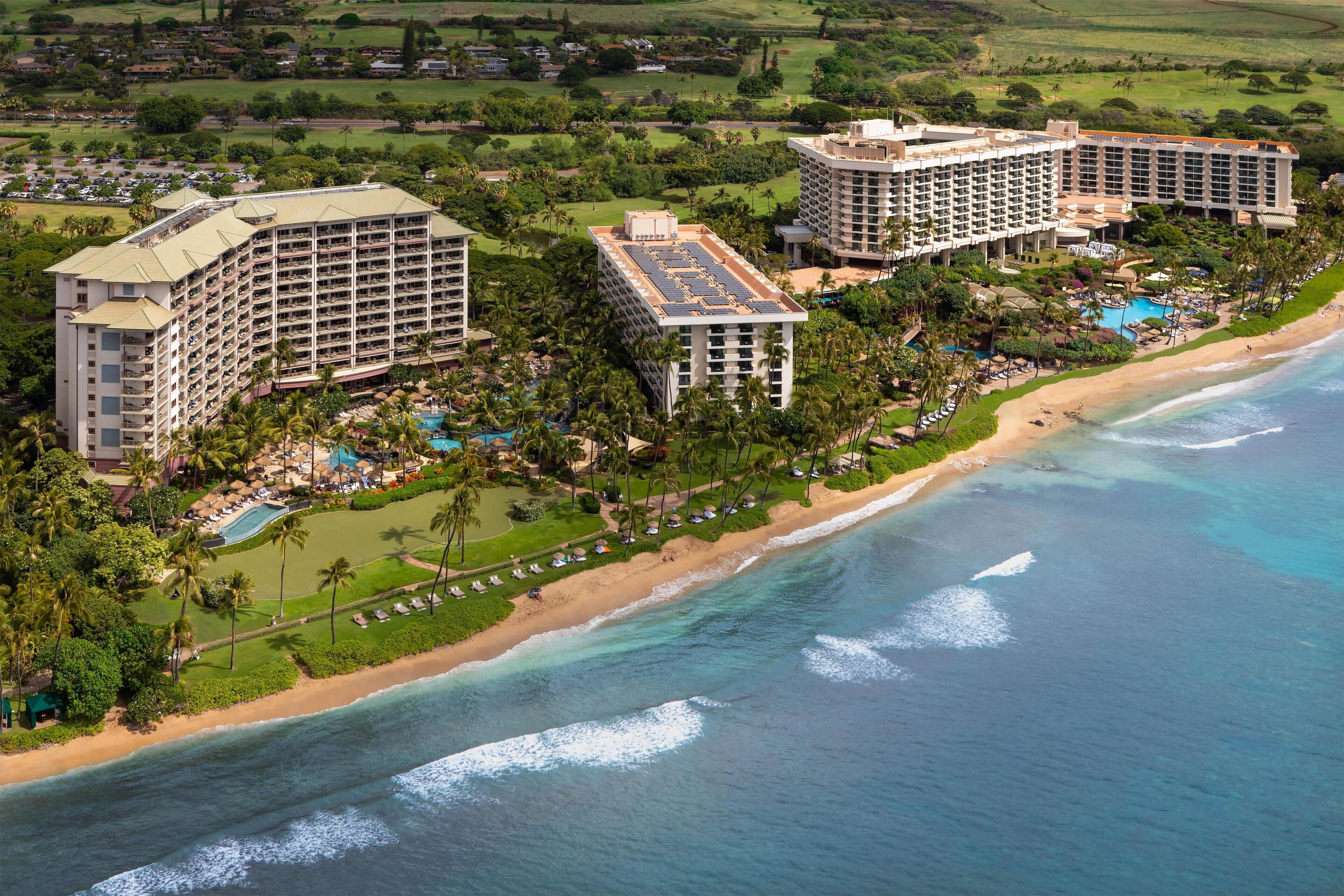A coastal resort with multiple high-rise buildings, a beachfront, and a swimming pool area.