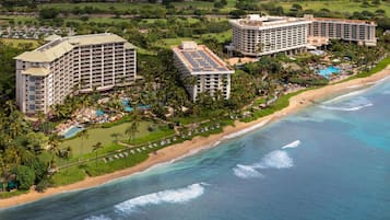 A coastal resort with multiple high-rise buildings, a beachfront, and a swimming pool area.