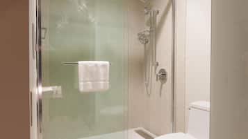 A bathroom with a glass-enclosed shower, a toilet, and a towel rack.