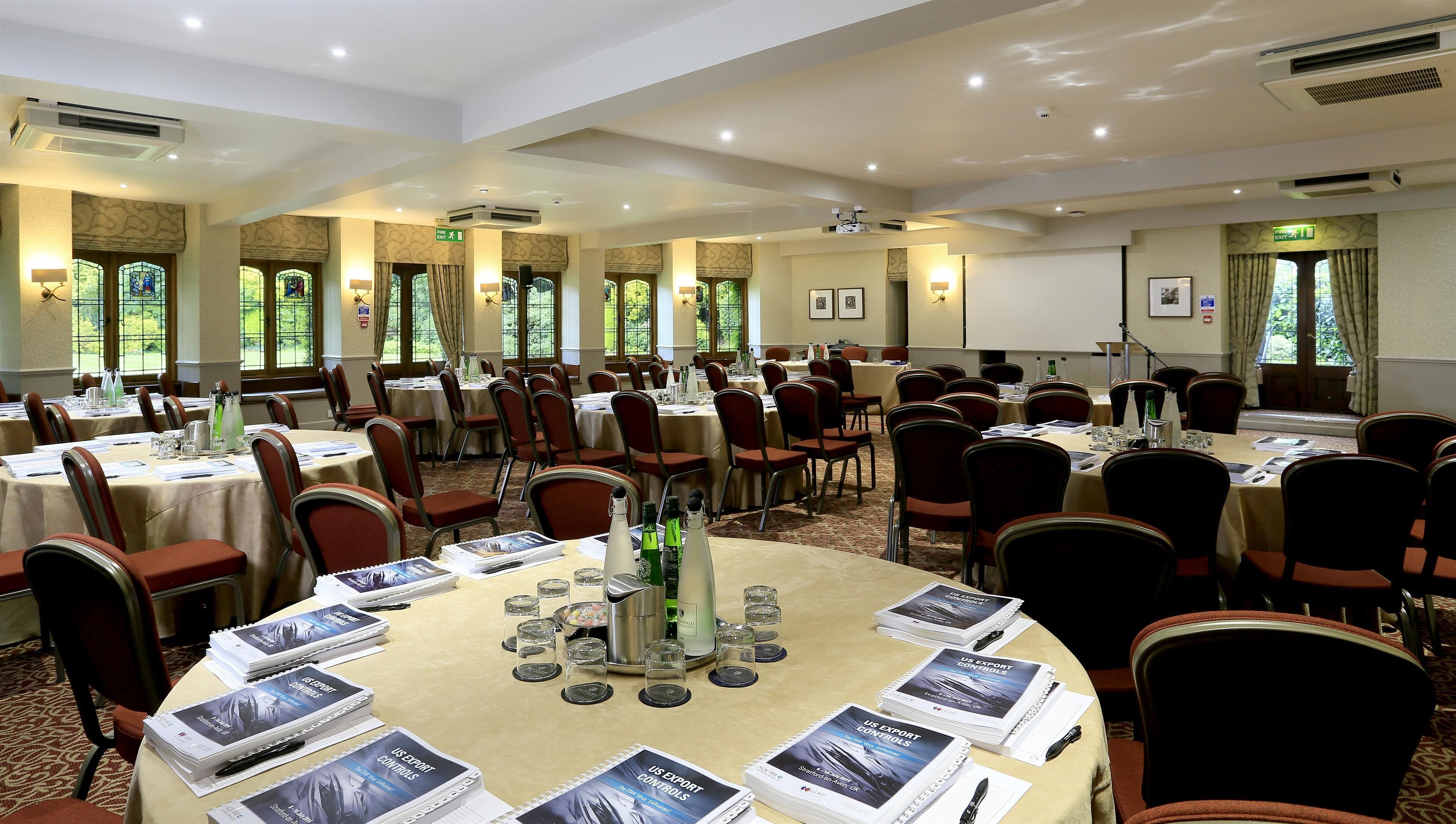 Une salle de conférence équipée de plusieurs tables, de chaises et de brochures d'information.