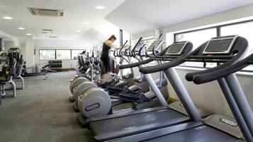 A gym with treadmills, dumbbells, and weight machines.