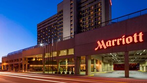 A Marriott hotel with a modern design, featuring a prominent sign, multiple floors, and a parking garage.